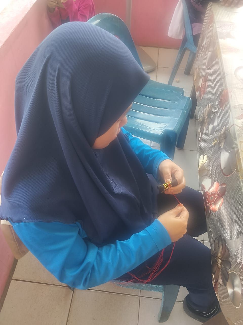 Menyulam benang merah pada jalur anyaman