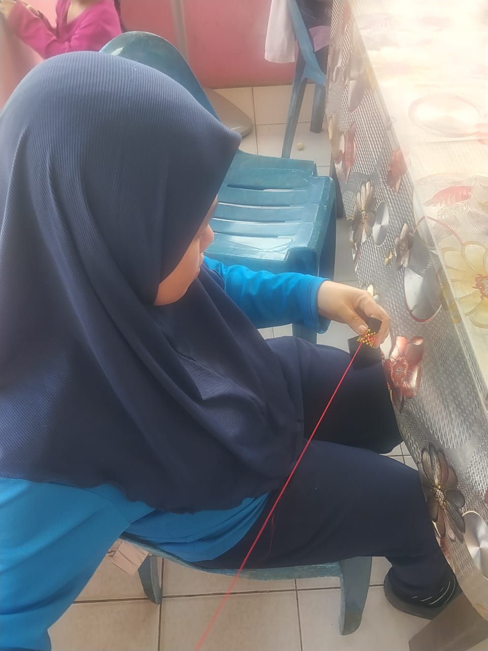 Menarik benang untuk membentuk corak